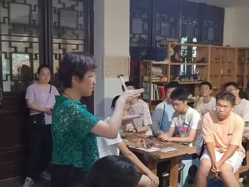 图为李江玉老师向实践队员讲解锡镶制作过程